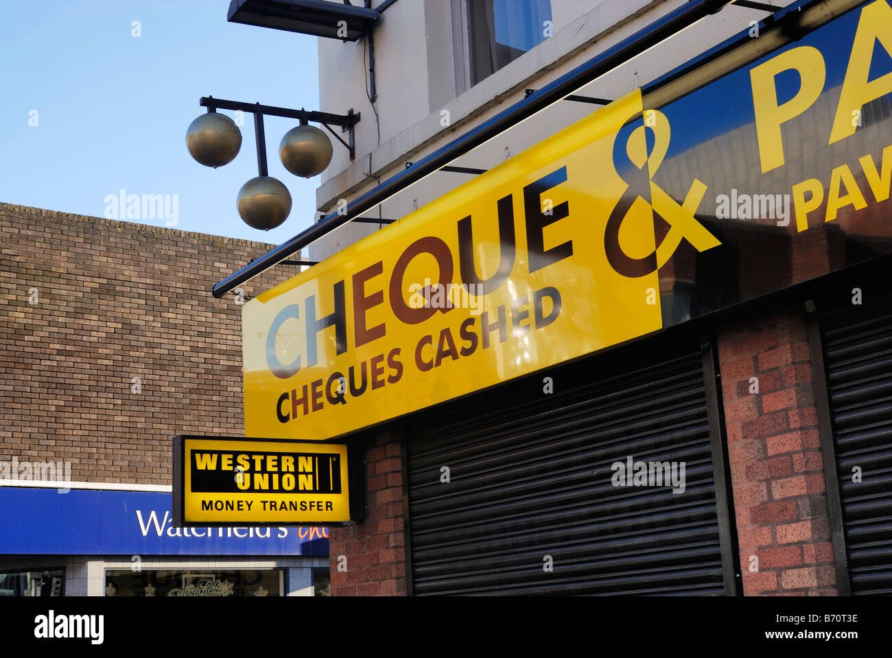 Pawnbrokers e denaro exchane shop in Warrington con sfere pawnbroker visualizzato sopra l'entrata. Foto Stock
