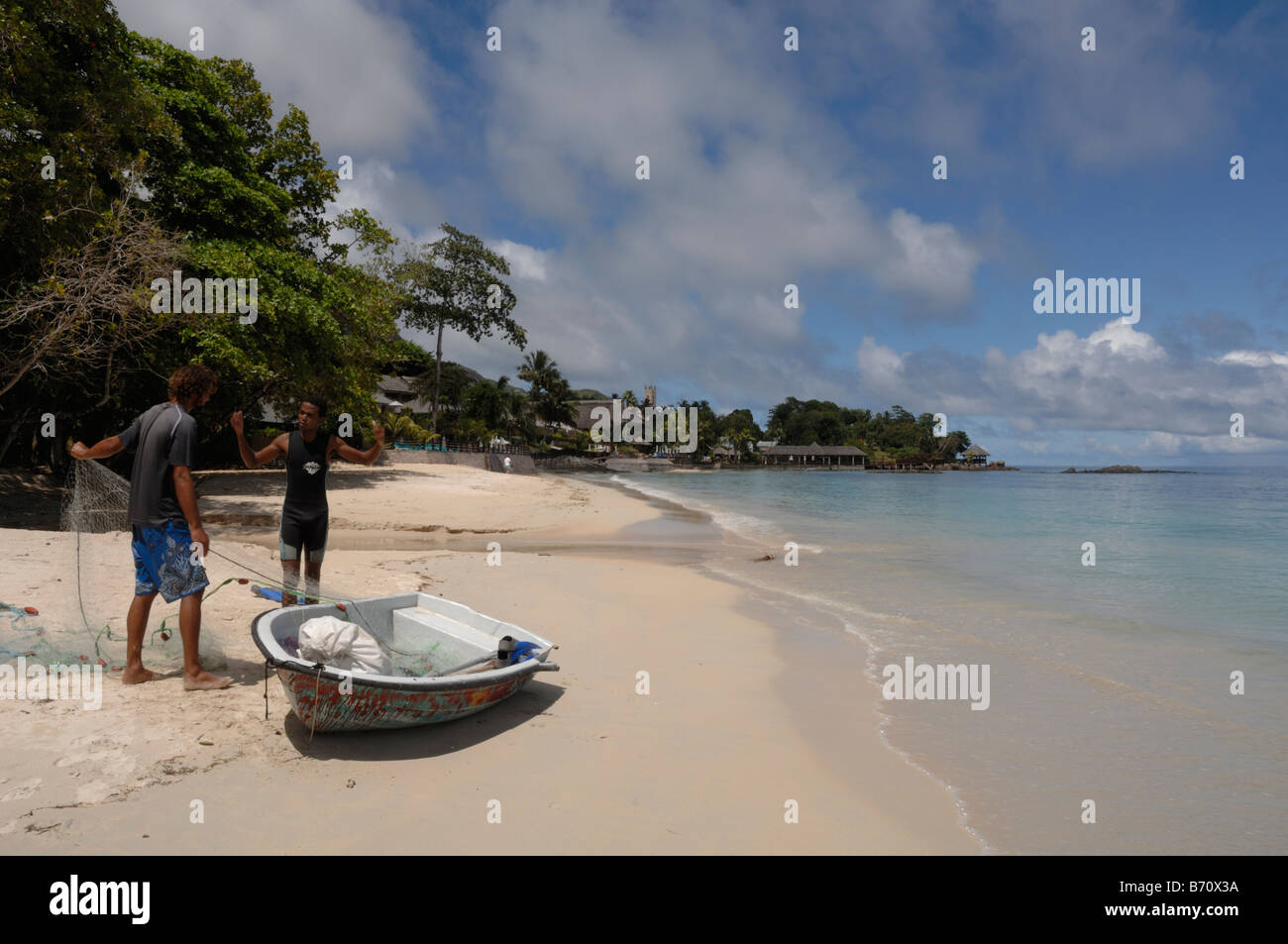 I pescatori sulla spiaggia e Meridien Hotel pescatori's Cove Beau Vallon Bay Mahe Seychelles Foto Stock