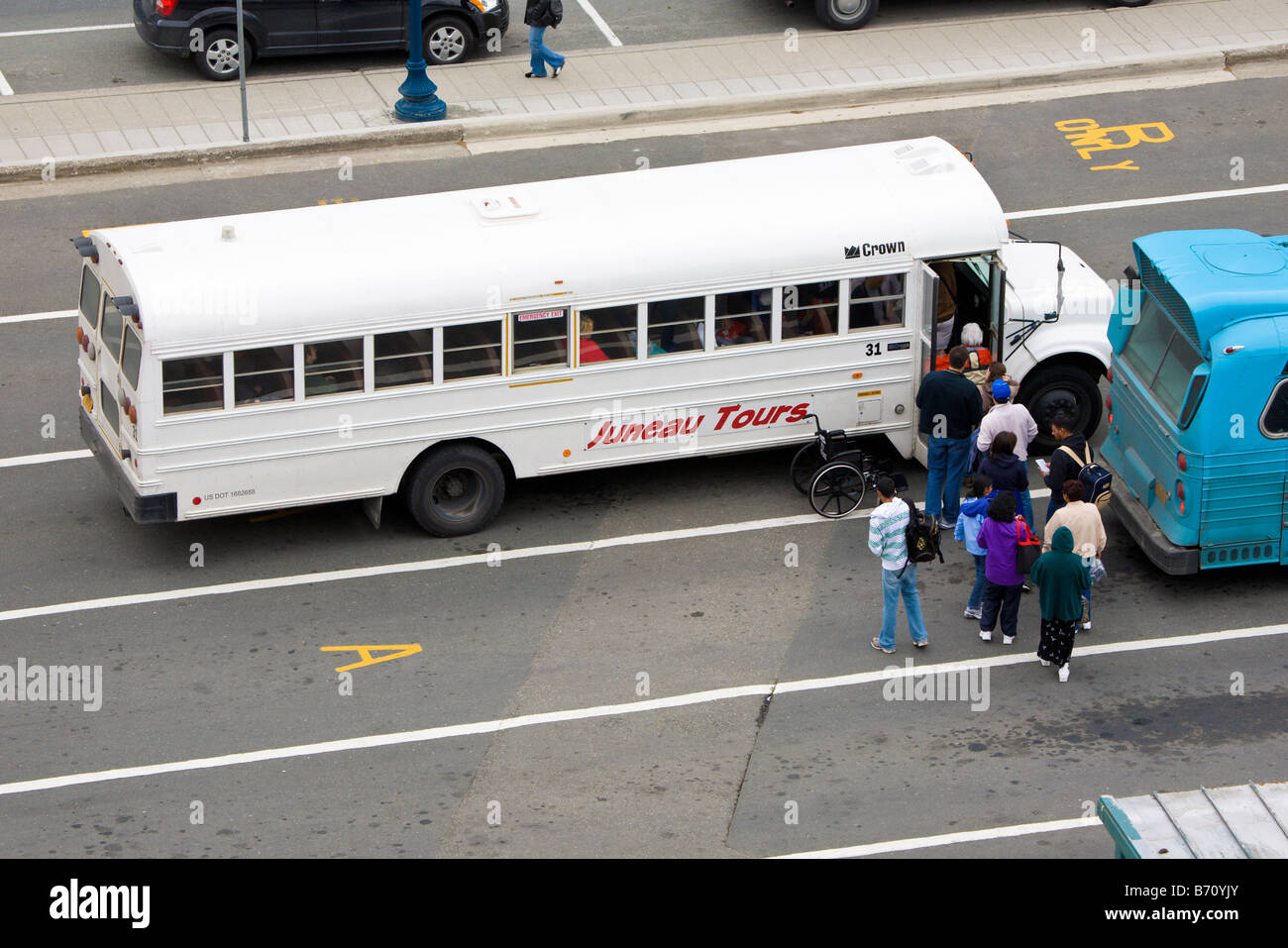 I turisti si sono schierate per ottenere su Juneau Tours tour bus al dock navi da crociera di Juneau, Alaska, STATI UNITI D'AMERICA Foto Stock