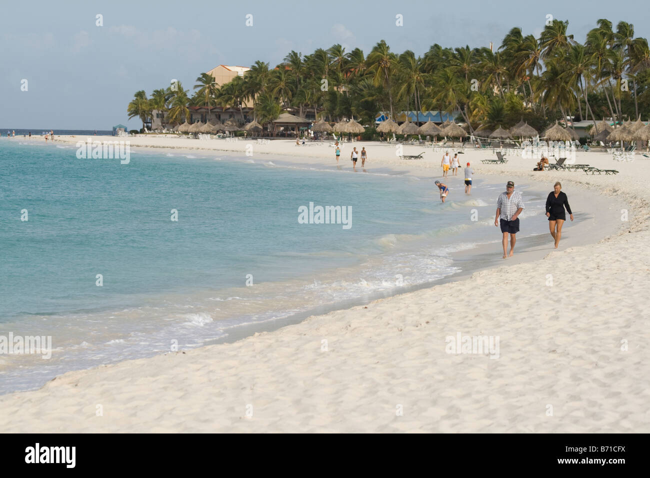 La gente camminare lungo Eagle Beach sull'isola caraibica di Aruba Foto Stock