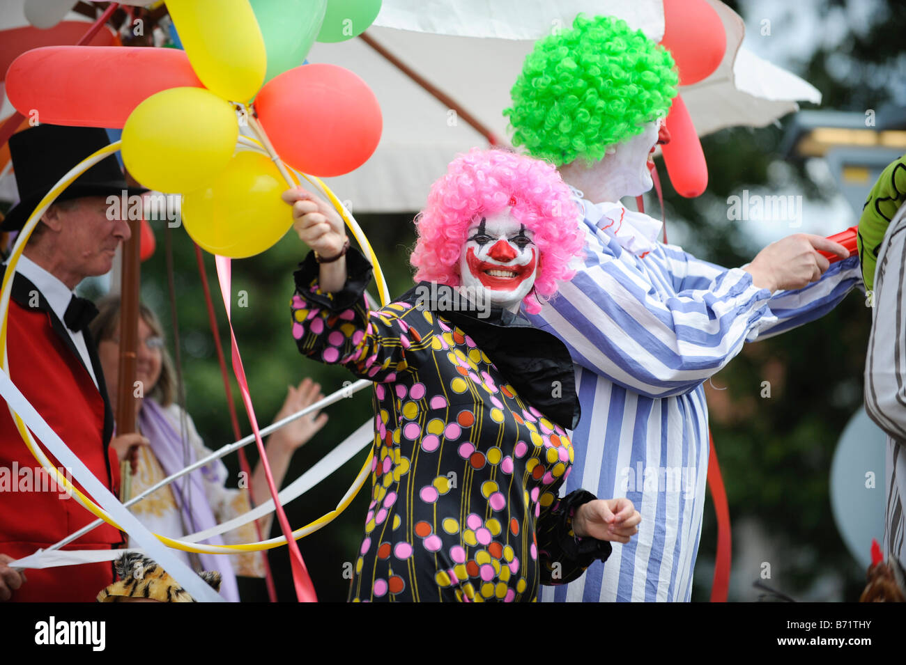 Una Donna vestita come clown onde da la processione come lei prende parte a Worthing carnevale. Foto da Jim Holden. Foto Stock