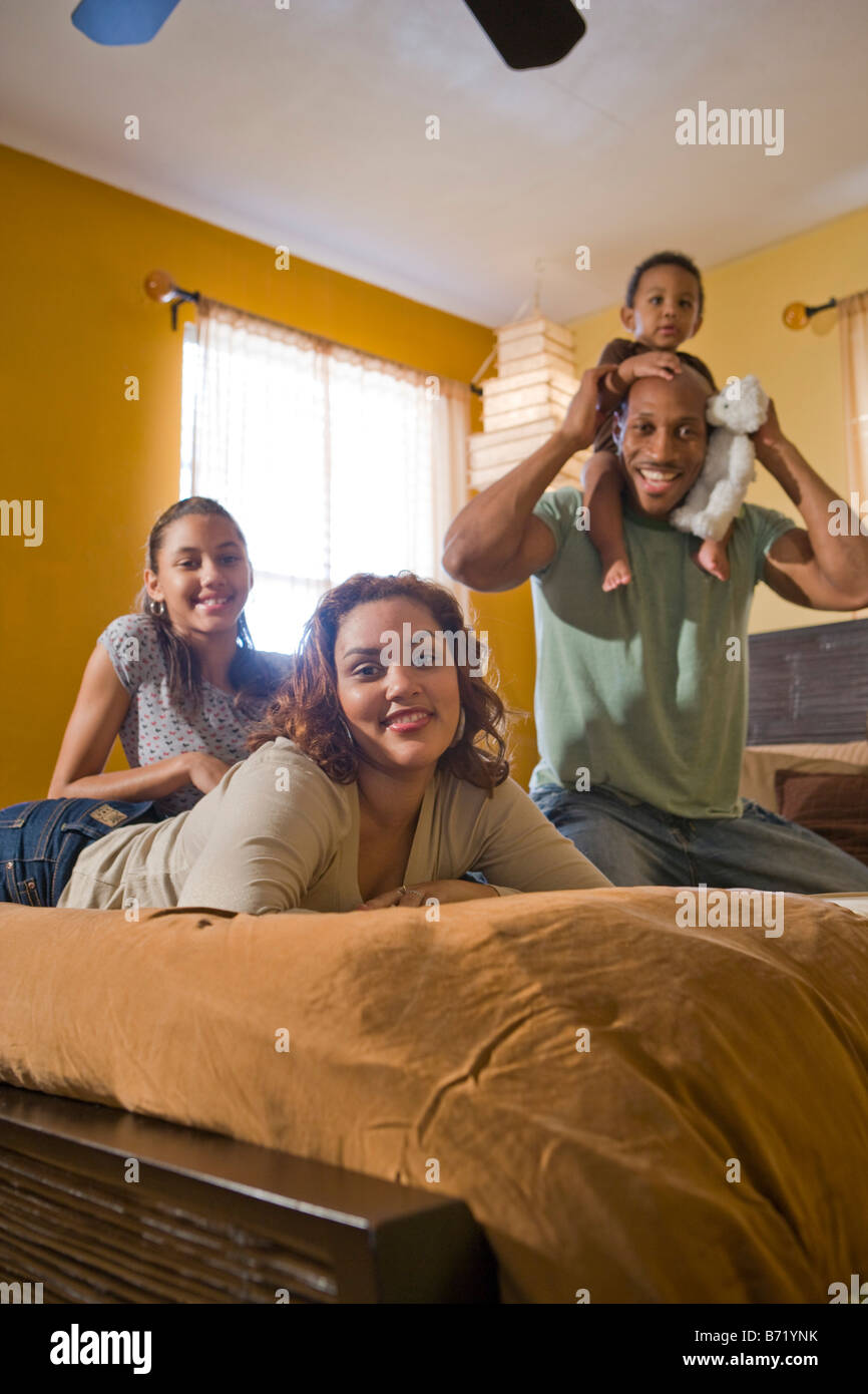 Felice famiglia americana africana rilassante sul letto Foto Stock