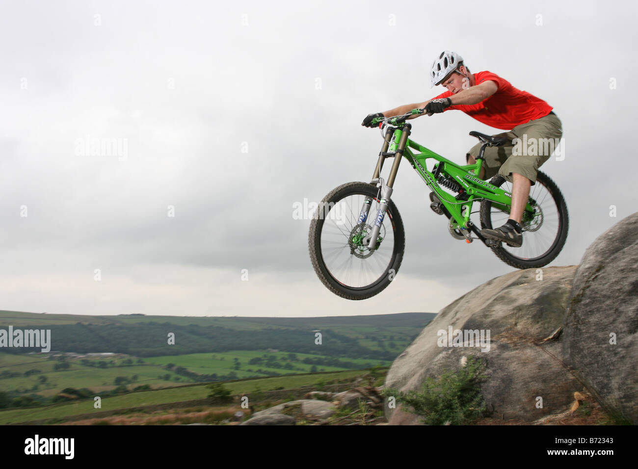 Un Mountain Biker in sella verso il basso una roccia sentiero coperto. Foto Stock