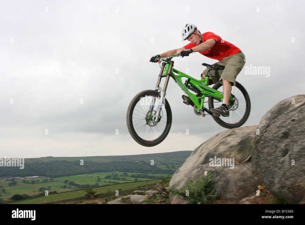Un Mountain Biker in sella verso il basso una roccia sentiero coperto. Foto Stock