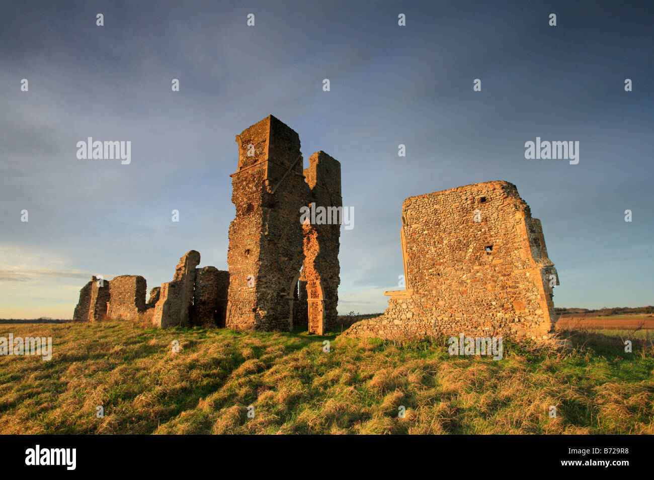 Le pareti in pietra e la torre delle rovine della chiesa Bawsey nel tardo pomeriggio la luce del sole. Foto Stock