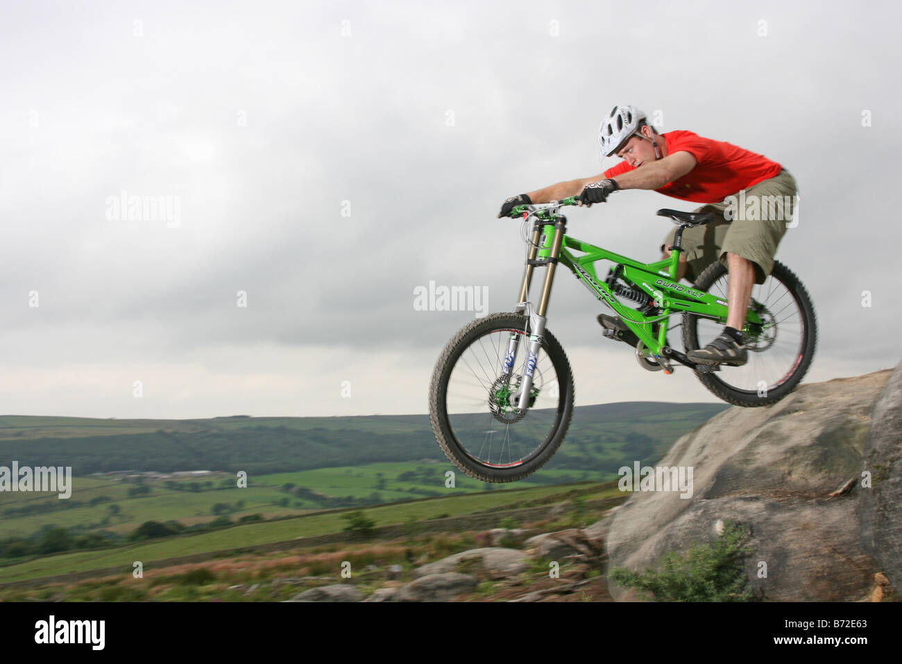 Un Mountain Biker in sella verso il basso una roccia sentiero coperto. Foto Stock