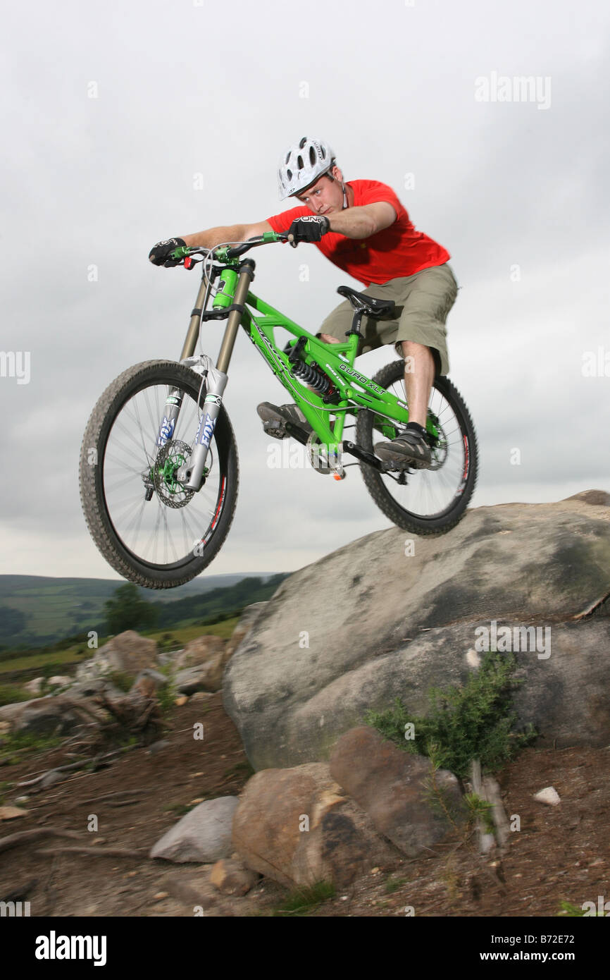 Un Mountain Biker in sella verso il basso una roccia sentiero coperto. Foto Stock