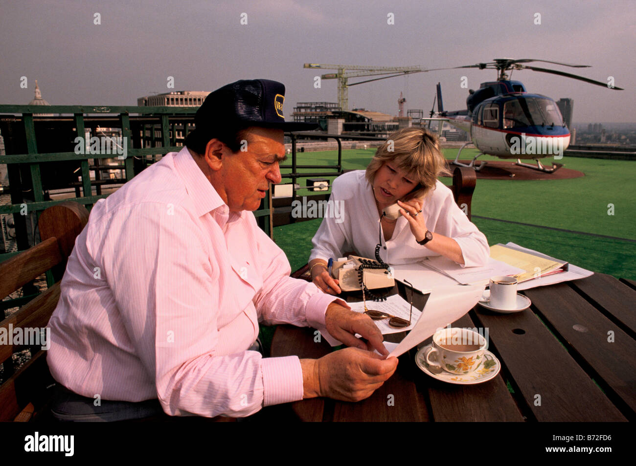 Robert Maxwell, media mogul, e proprietario del gruppo specchietto quotidiani, colloqui con il suo segretario sul tetto dell'edificio a specchio. Foto Stock