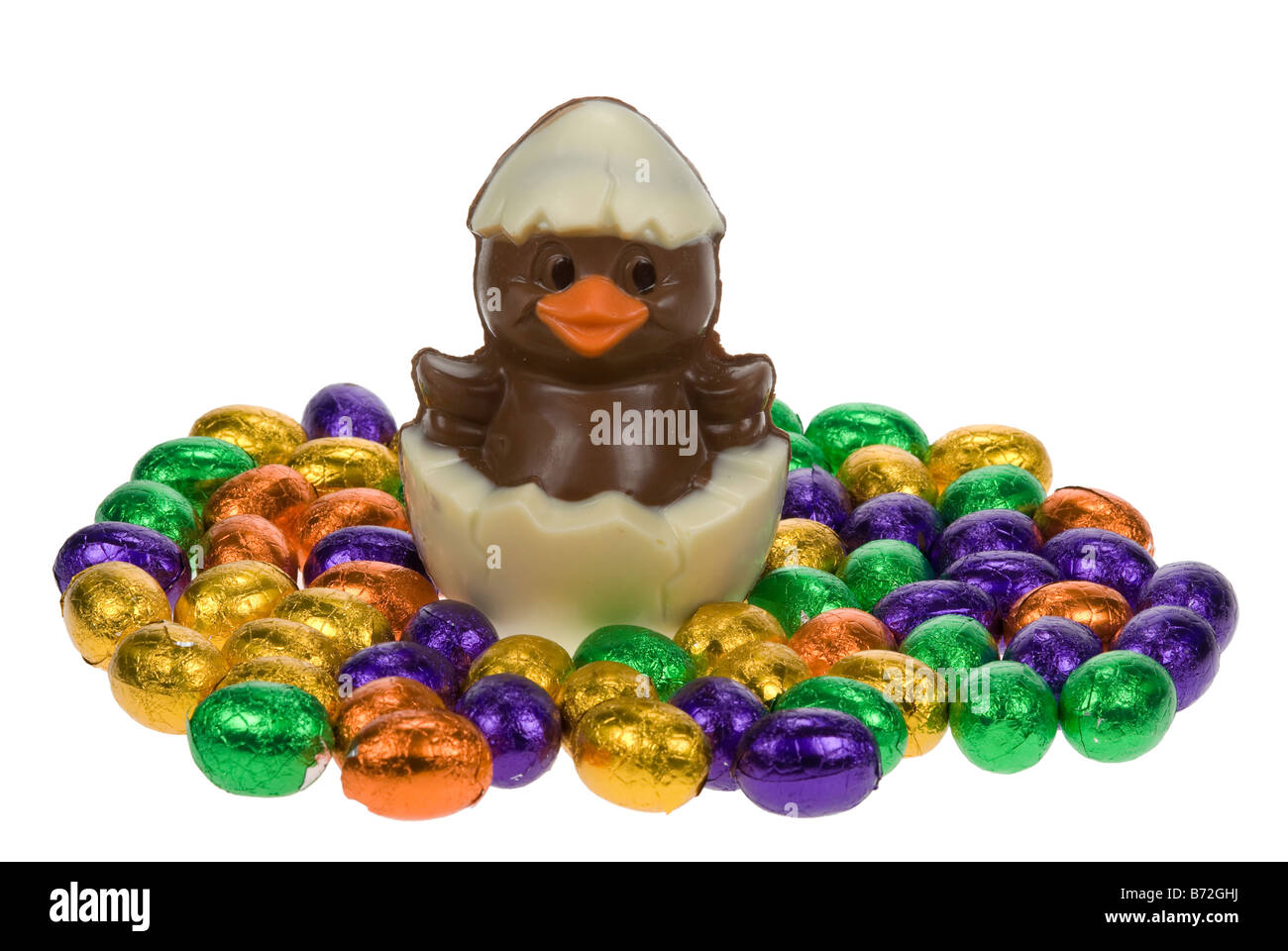 Carino pulcino di pasqua circondato da uova di pasqua di cioccolato isolato su sfondo bianco Foto Stock