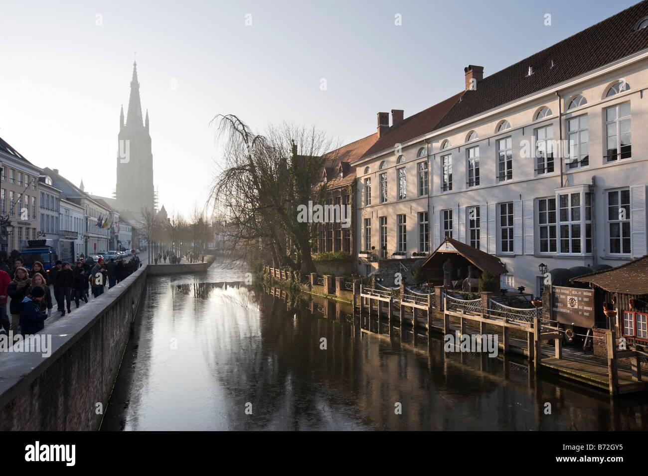 Bruges, Belgio. Inverno vista canale e Onze Lieve Vrouwekerk chiesa nel centro storico. Foto Stock