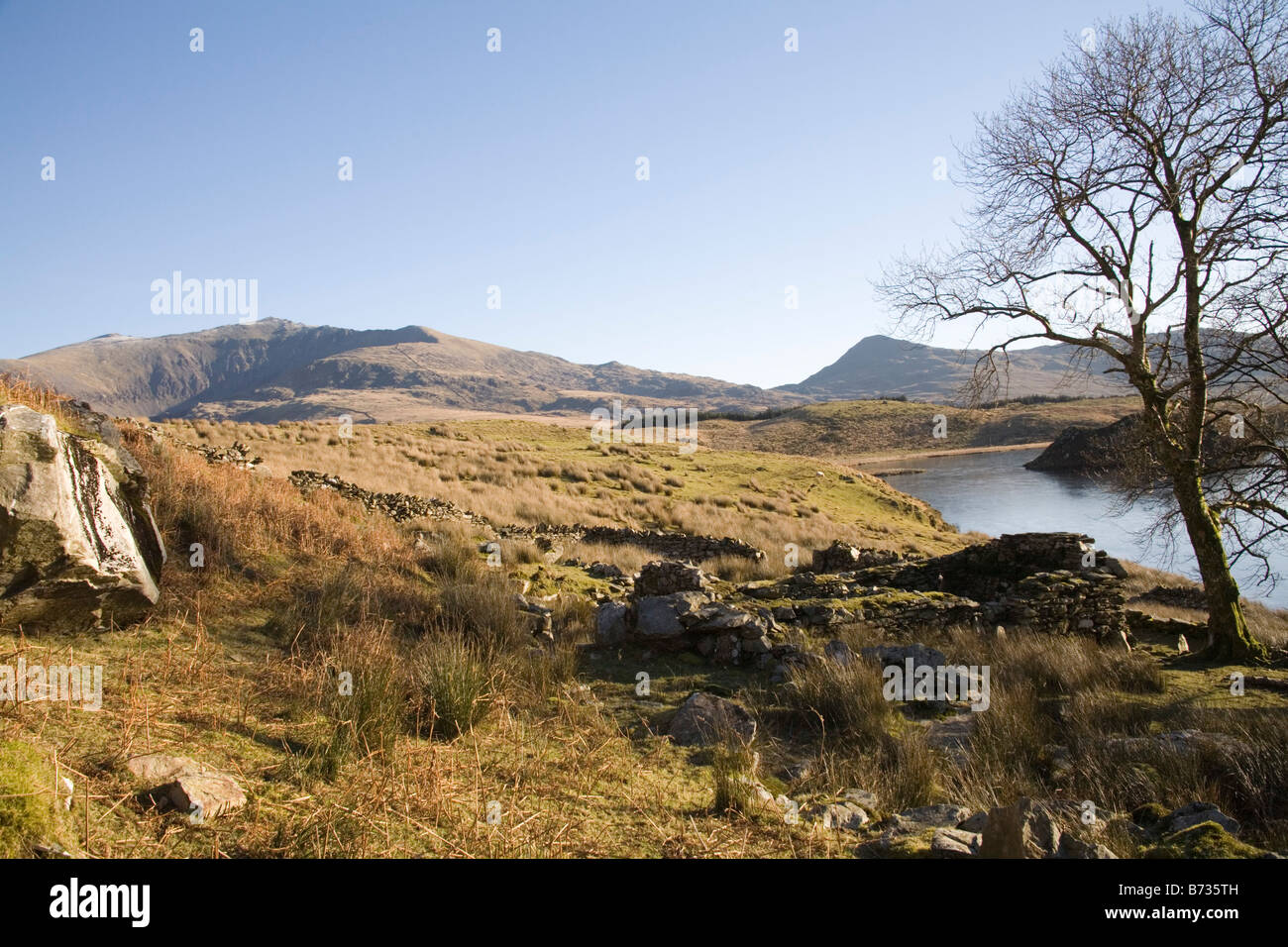Rhyd Ddu Gwynedd Galles del Nord gennaio guardando attraverso il lago ghiacciato Llyn y Dywarchen verso Snowdon con un edificio rovinato Foto Stock