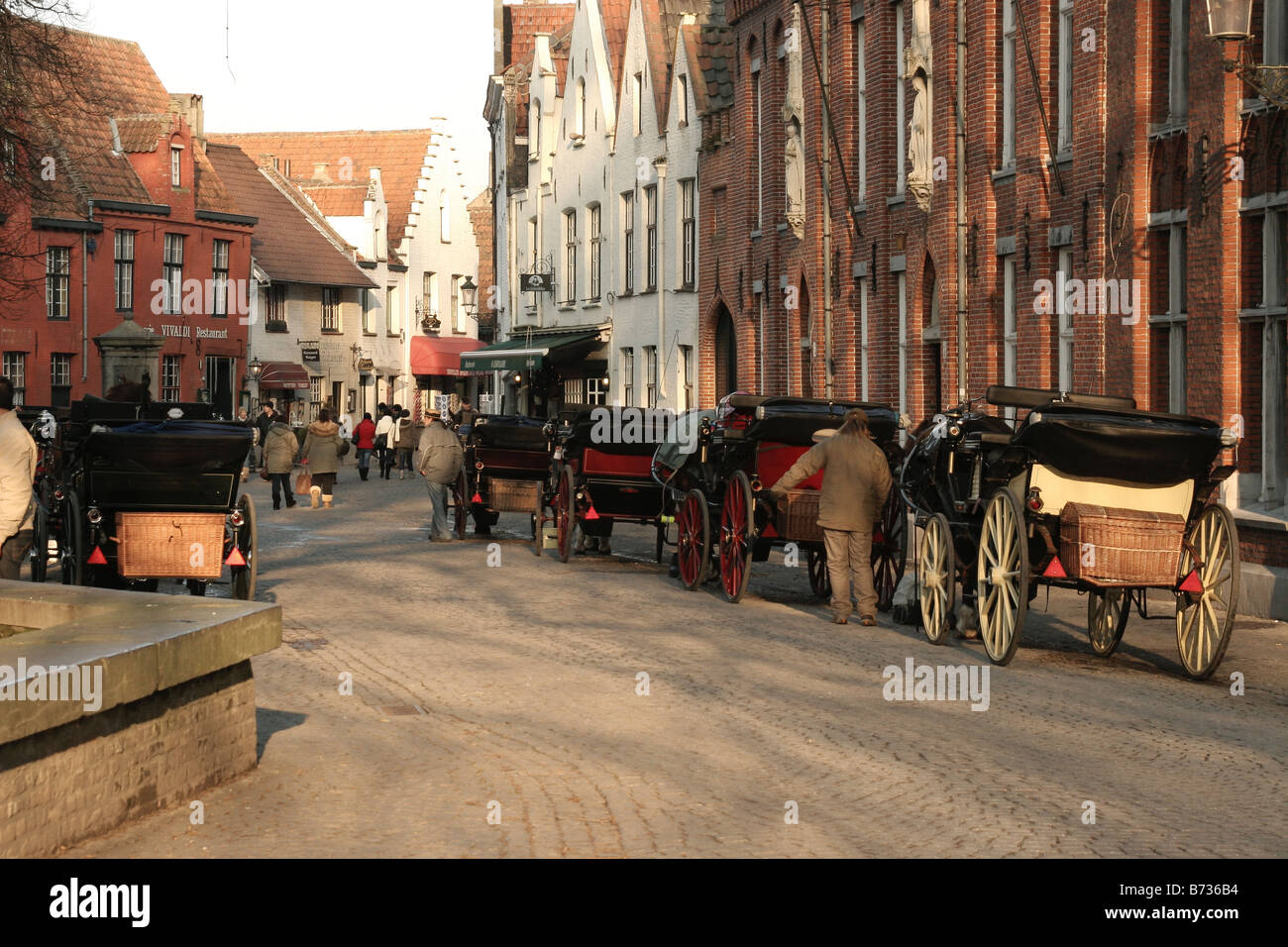 Street con cavalli e carri in Brugge Belgio Foto Stock