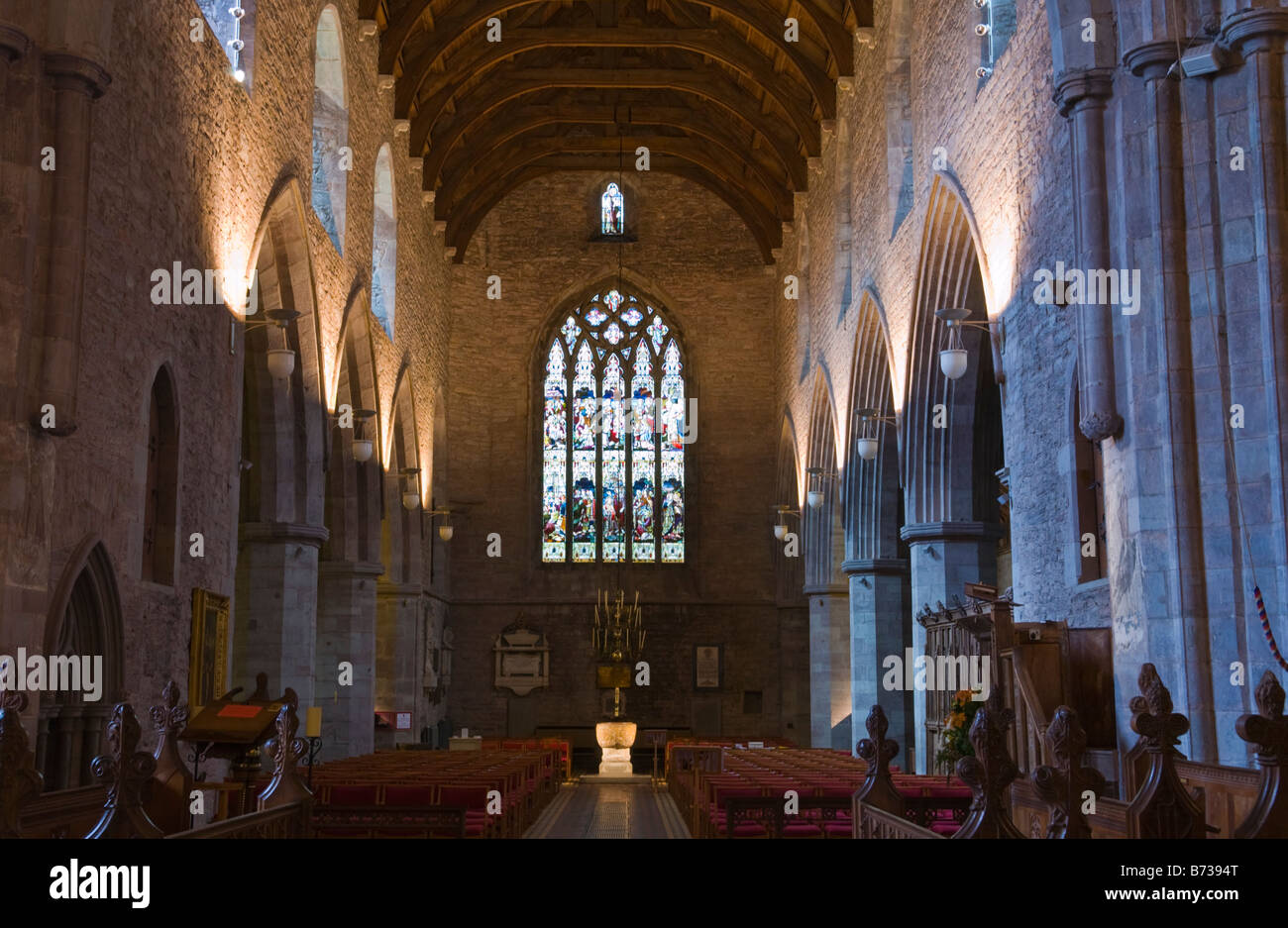 Interno della cattedrale di Brecon Galles POWYS REGNO UNITO guardando verso il XII secolo in pietra di epoca normanna font Foto Stock