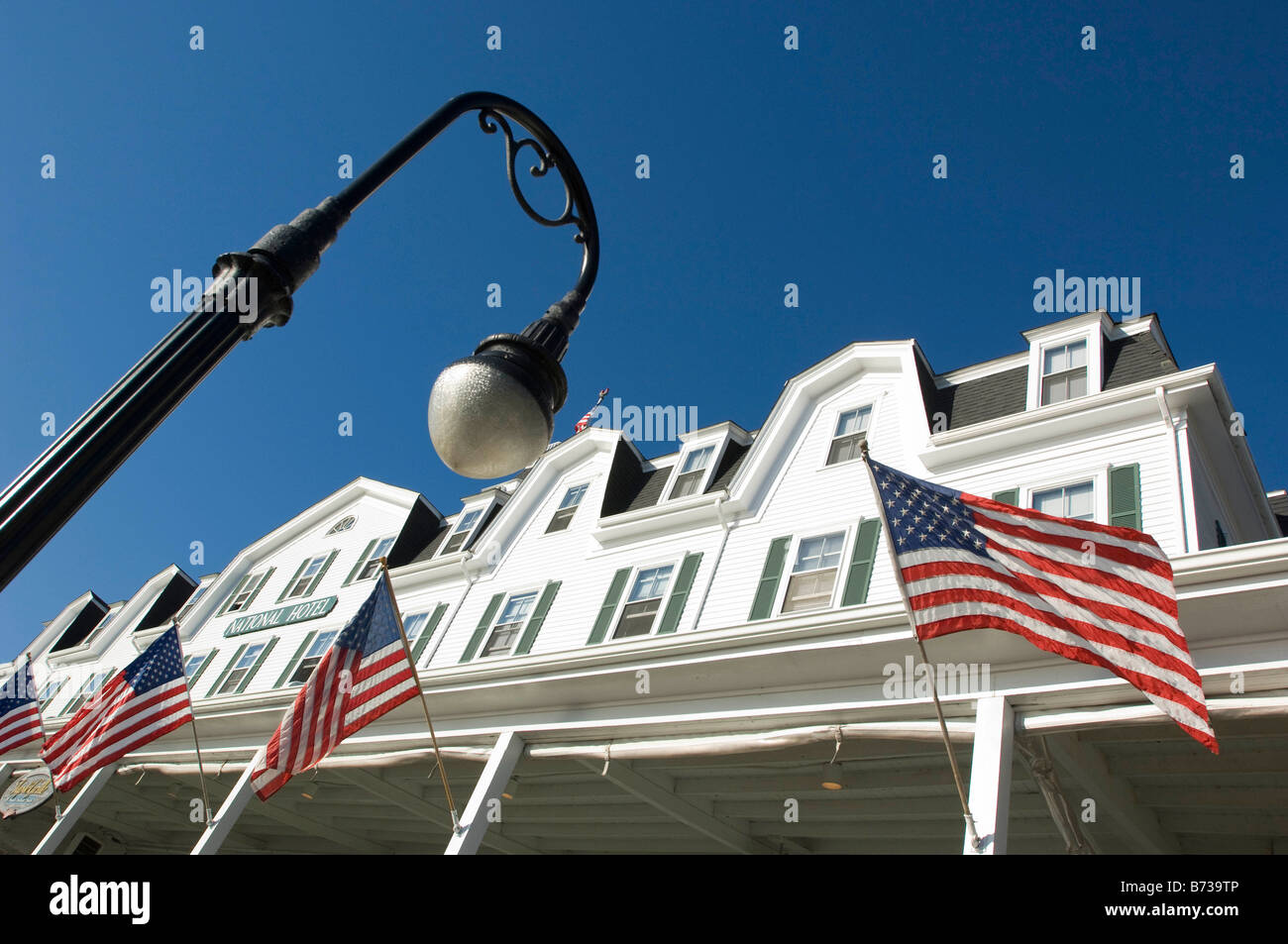 Antique hotel vittoriano con bandiera americana e un lampione, Block Island, Rhode Island, Stati Uniti d'America. Foto Stock