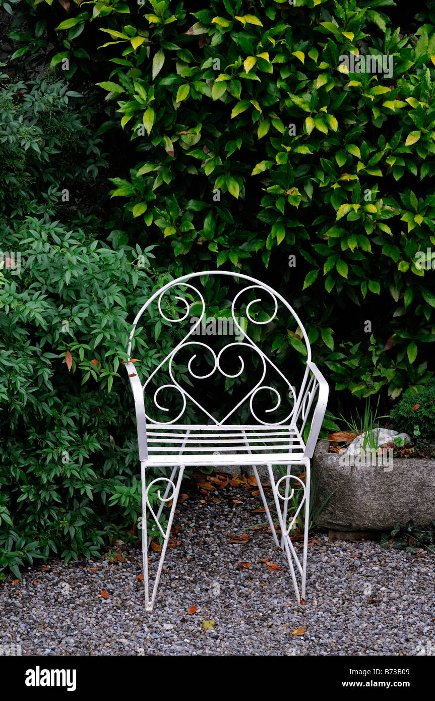 Battuto metallo bianco giardino formale del sedile nella parte anteriore della copertura Foto Stock