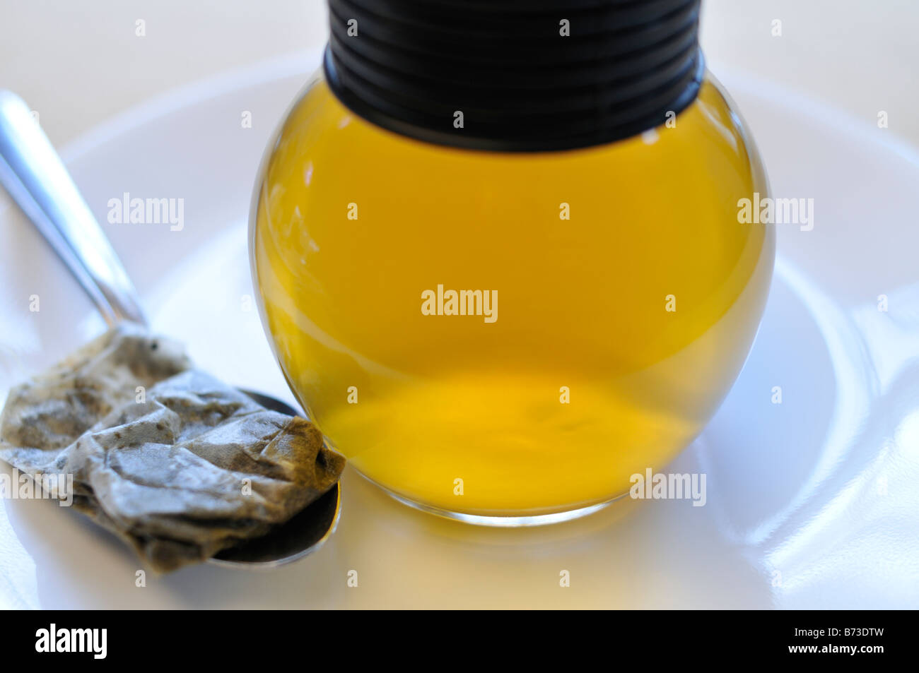 Il tè verde nella caraffa di vetro con bustine di the sul cucchiaio Foto Stock