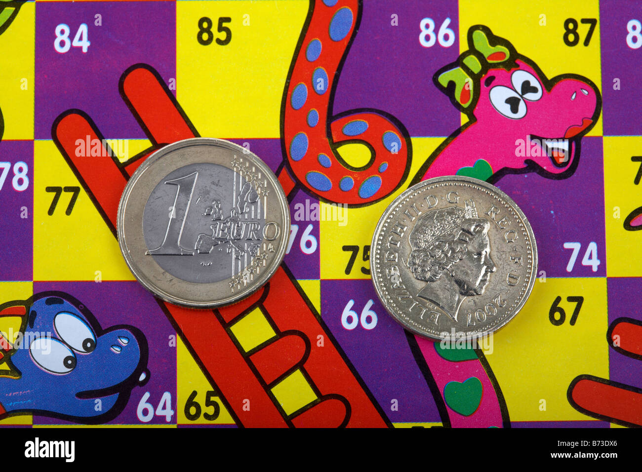 Una moneta in euro e sterlina moneta su un serpenti e scale con scheda di euro sulla scaletta e cancelletto sullo Snake Foto Stock