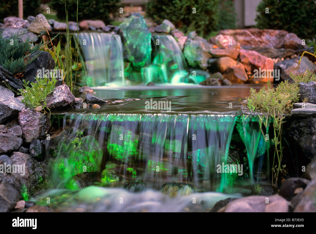Cascate in Minnesota e giardino. In fibra ottica di illuminazione subacquea  proietta un bagliore verde. L'estate Foto stock - Alamy