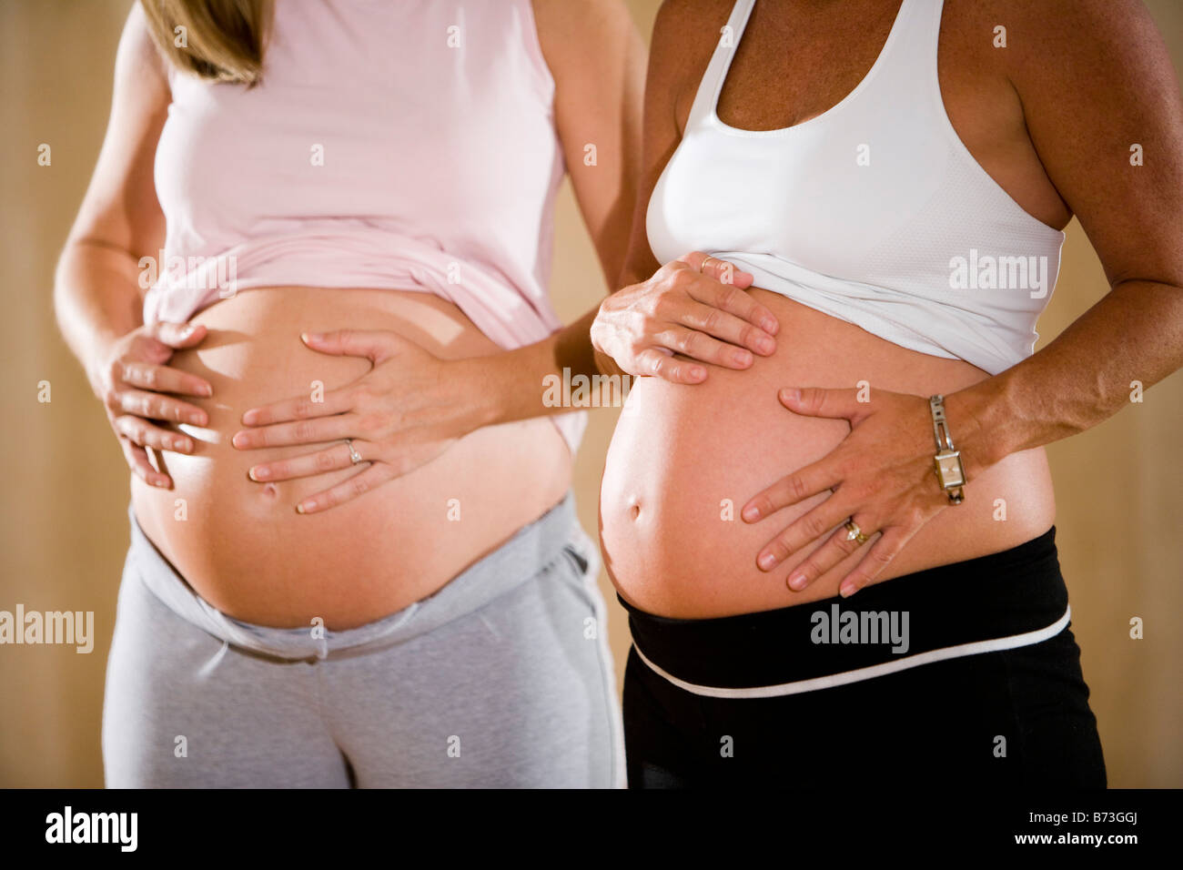 Donne in stato di gravidanza mantenendo le loro addome, vista ritagliata Foto Stock