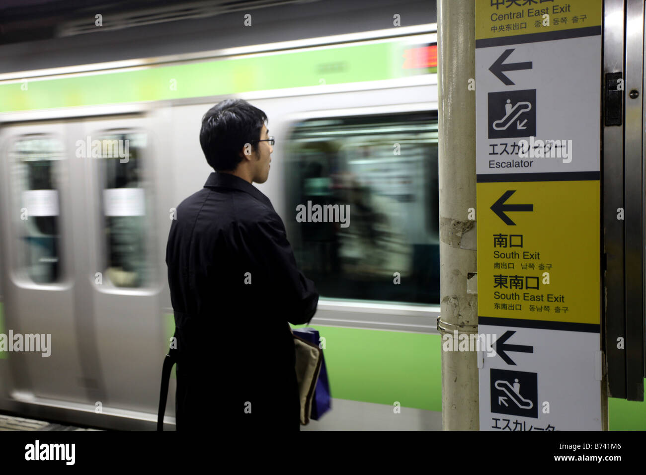 Un passeggero vi aspetta per il treno alla fermata sulla piattaforma presso la stazione JR di Shinagawa stazione ferroviaria sulla Linea Yamanote Foto Stock