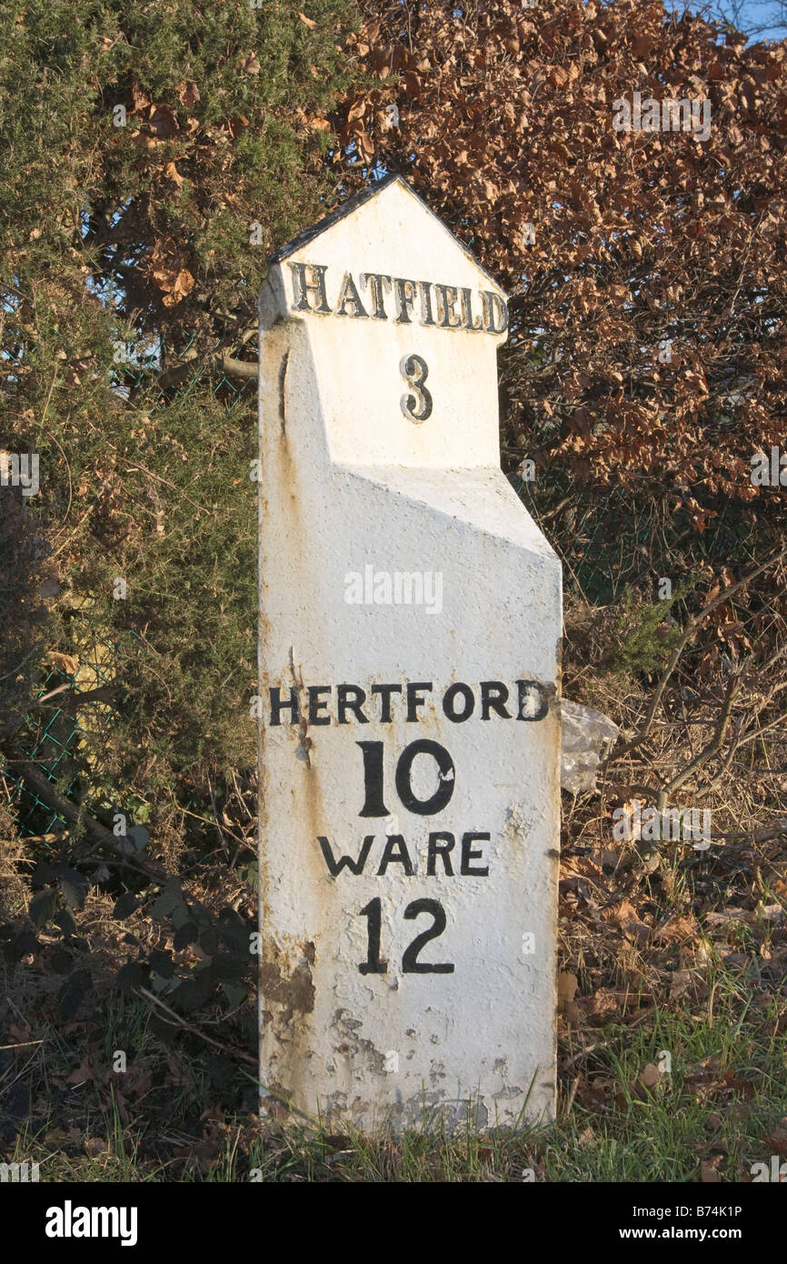 Milepost bianco che mostra la distanza a Hatfield Hertford e Ware Foto Stock