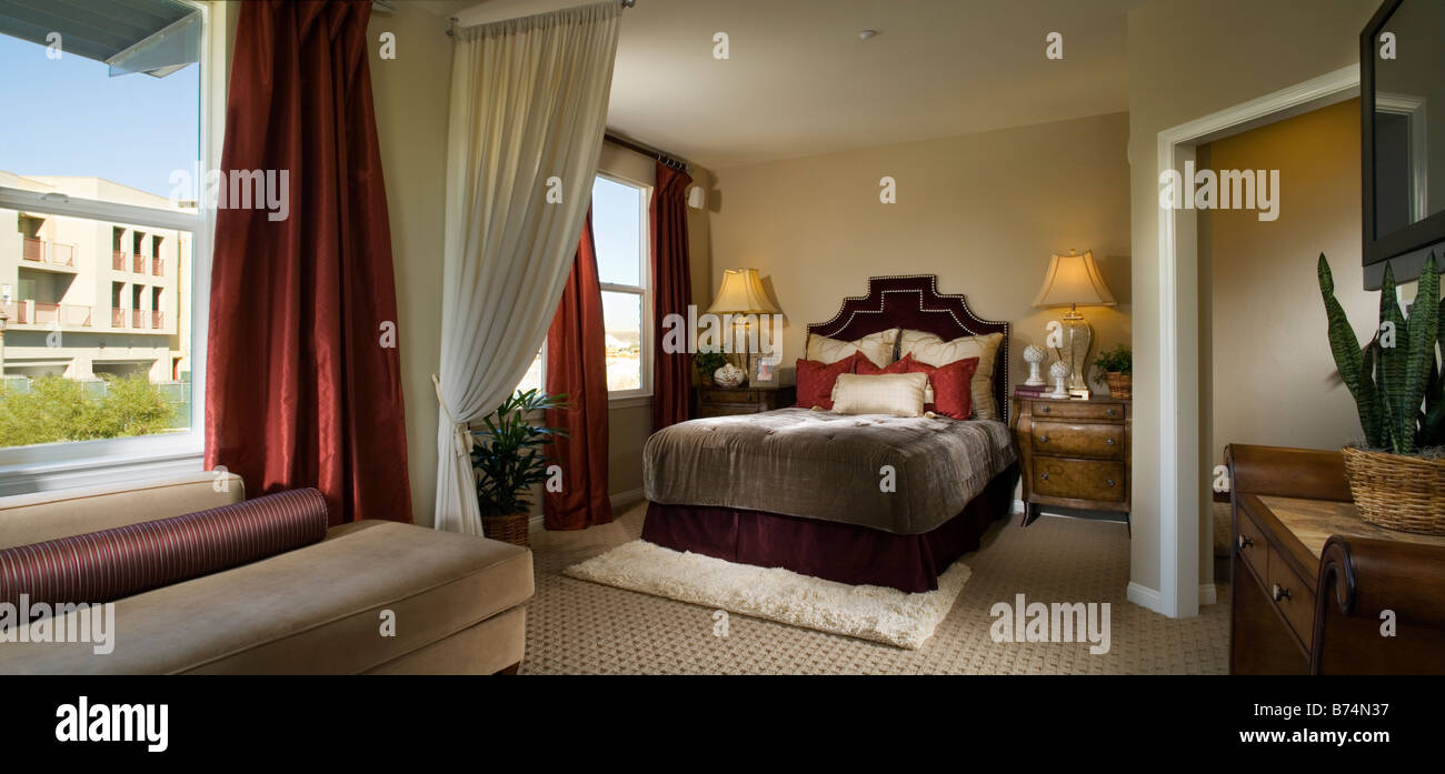 Elegante camera da letto padronale con accenti rossi Foto Stock