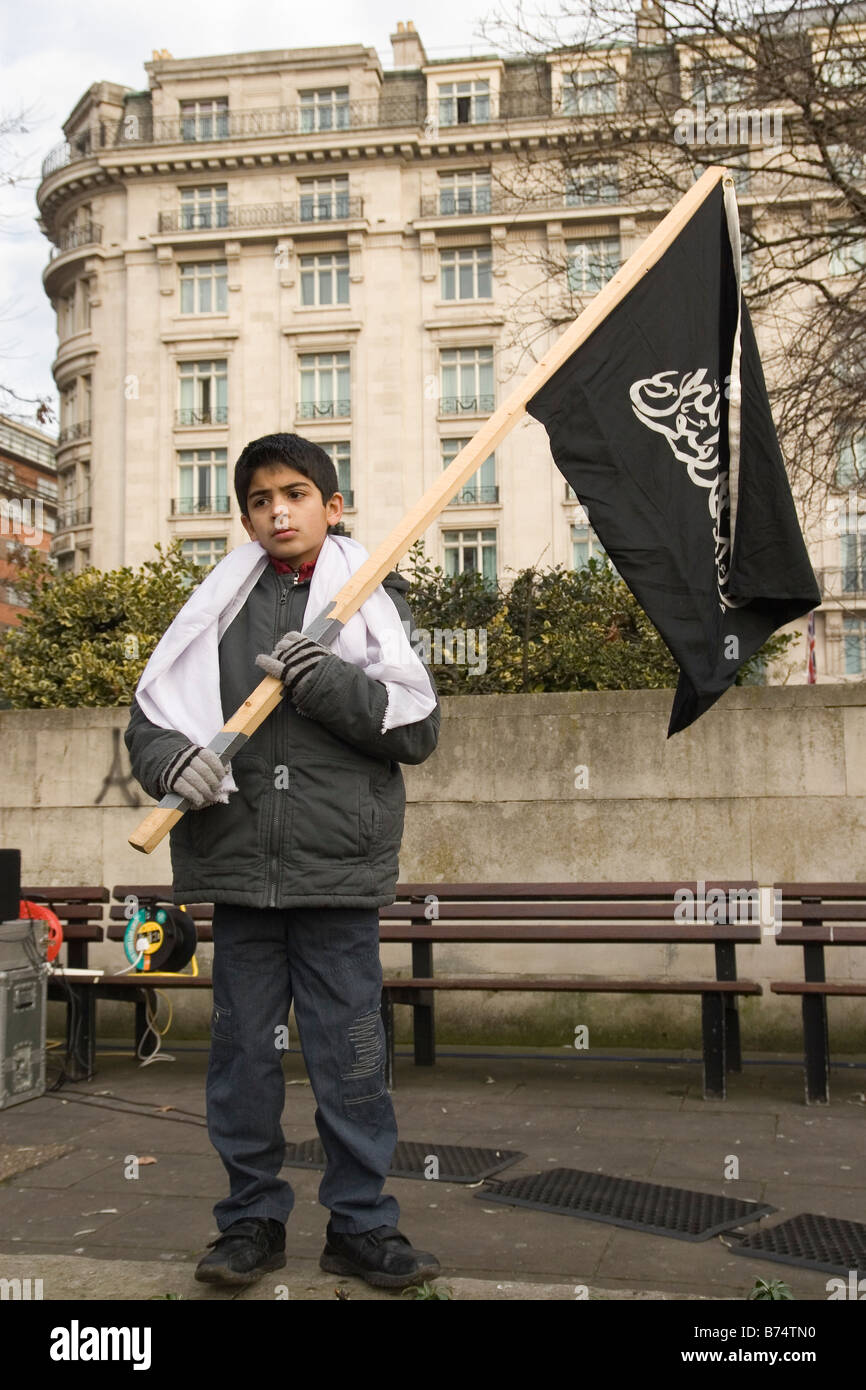 Giovane ragazzo musulmano holding bandiera islamica durante il rally in Marble Arch chiamando per la Jihad Foto Stock