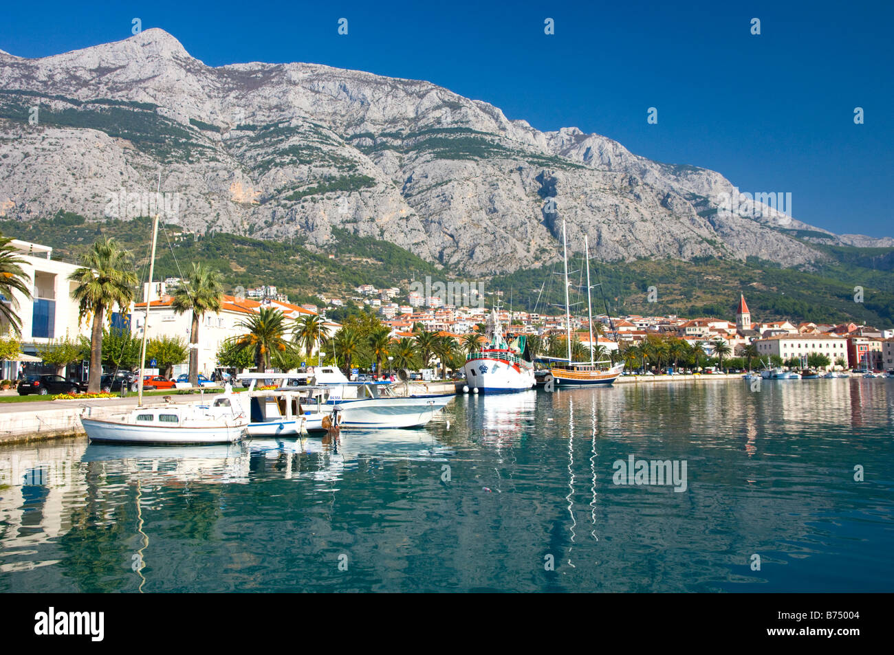 Il porto con una passeggiata sul lungomare e barche da pesca in Croazia Makarska Foto Stock