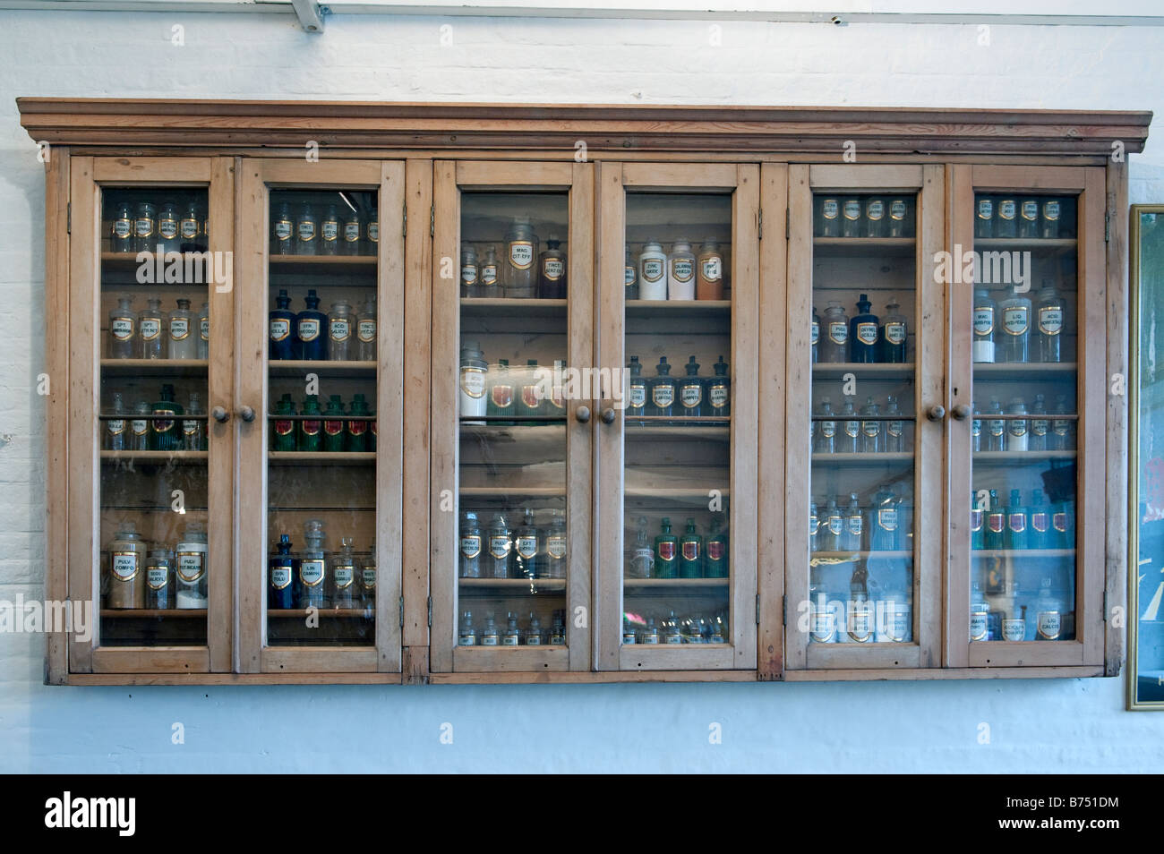 Cabinet in legno contenenti vasi di coloranti e prodotti chimici utilizzati nella lana in processi decisionali Foto Stock