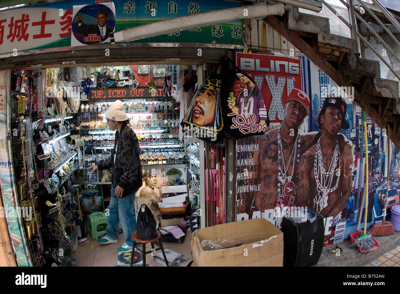 I lavoratori passano attraverso uno stretto vicolo collegamento sul loro modo di lavorare al di sotto di un negozio chiuso segno che è specializzato nell'esportazione a c Foto Stock