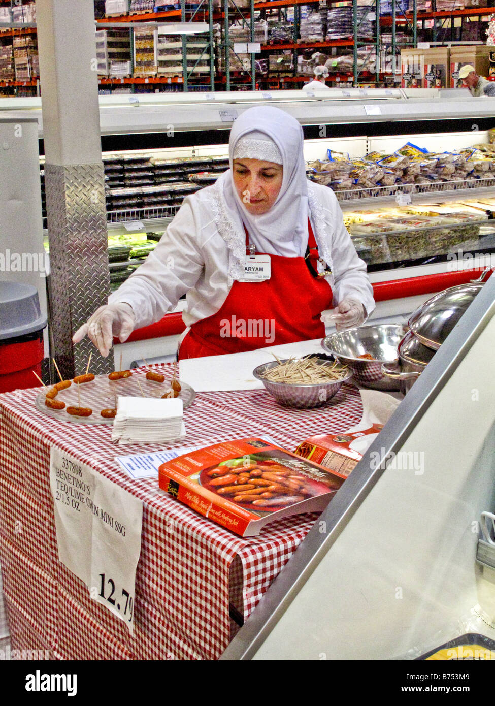 Un addetto di imposta un display del cibo gratuito dei campioni a una Laguna Niguel CA big box store nota testa musulmano sciarpa Foto Stock