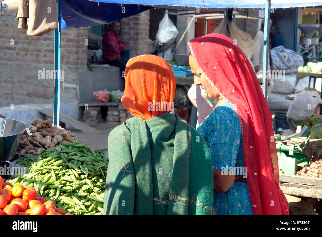 Due donne indiane in abito tradizionale shopping a bikaner mercato ortofrutticolo in stallo Foto Stock