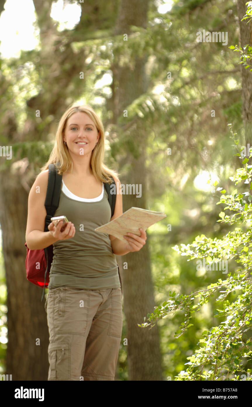 Giovane donna con il tipo di GPS del dispositivo e mappa di boschi, Regina, Saskatchewan Foto Stock