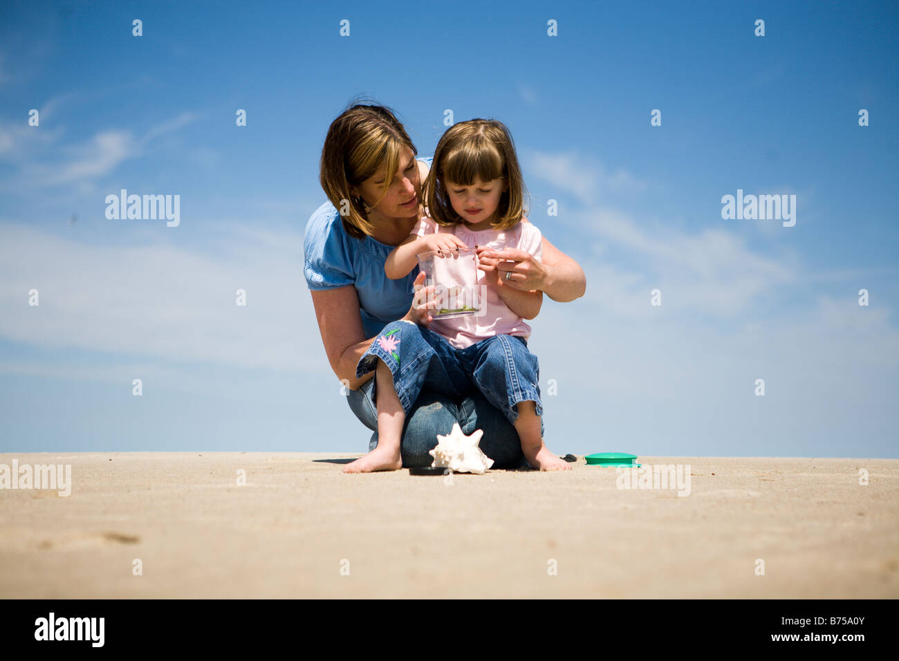 Donna e bambina (4) Guardare ladybugs nel vaso di raccolta, Grand Beach Parco Provinciale, Manitoba, Canada Foto Stock