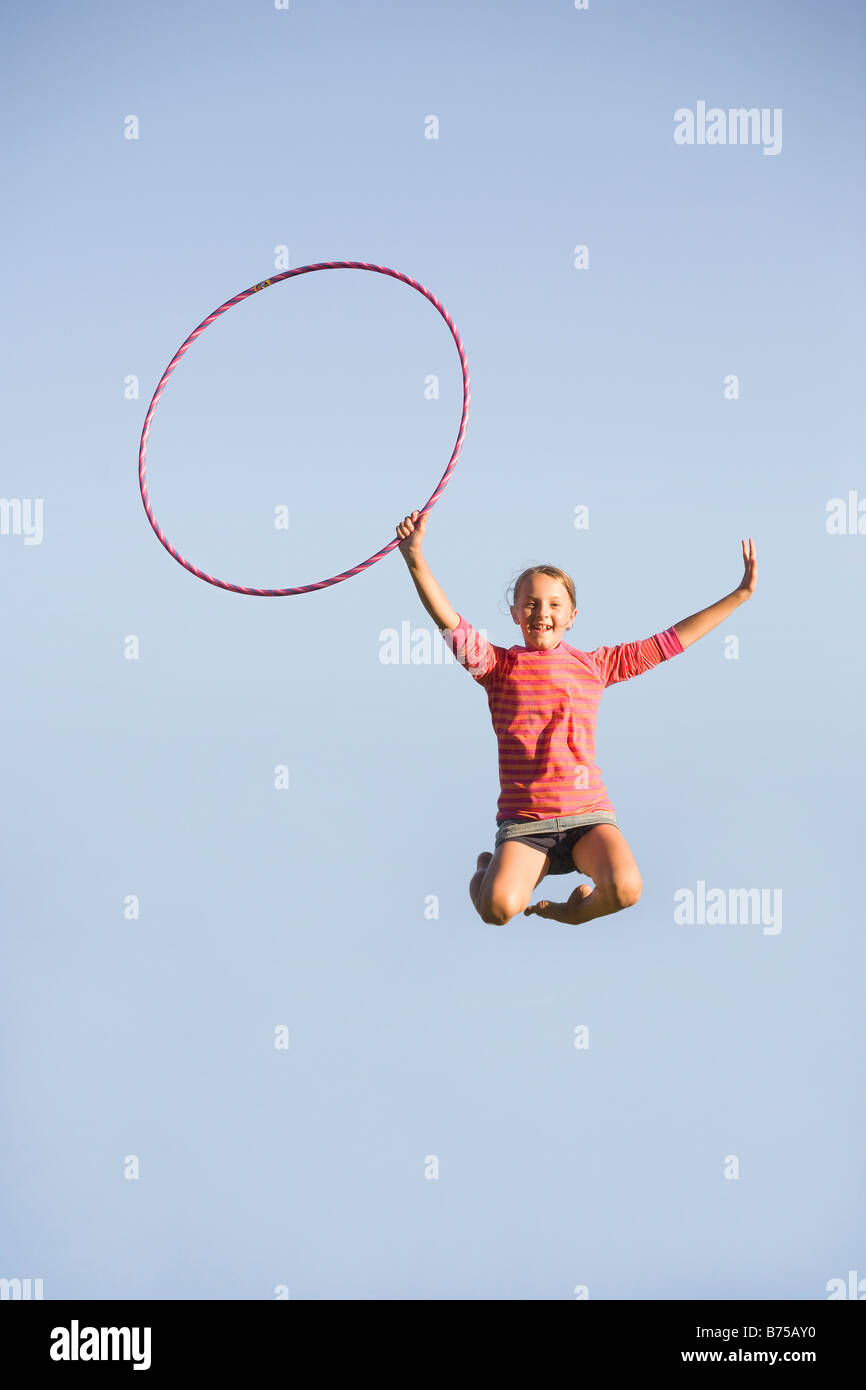 11 anno vecchia ragazza salta in alto con hula hoop, Winnipeg, Manitoba, Canada Foto Stock