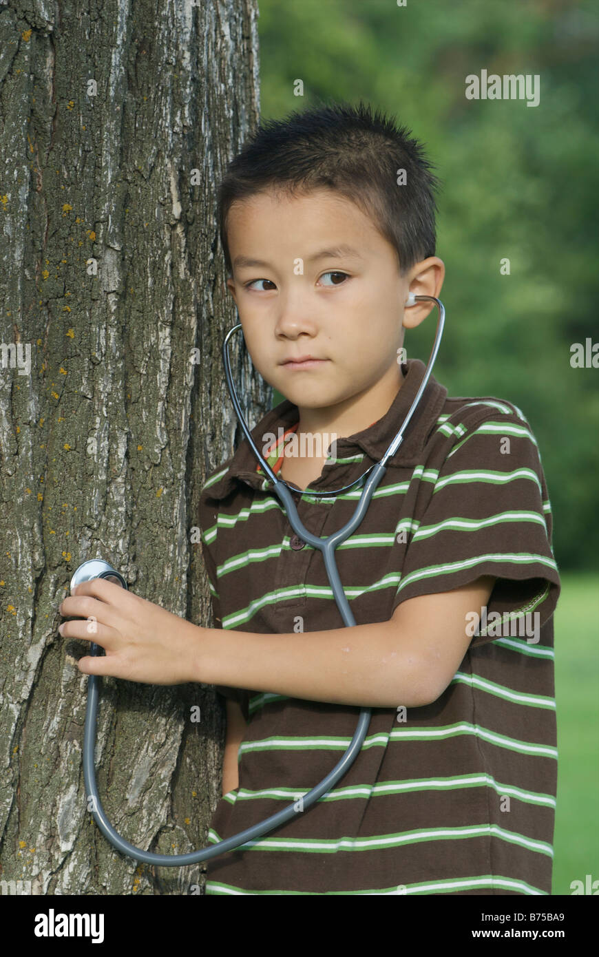 Sette anni di vecchio ragazzo con stethescope posto su albero, Winnipeg, Canada Foto Stock