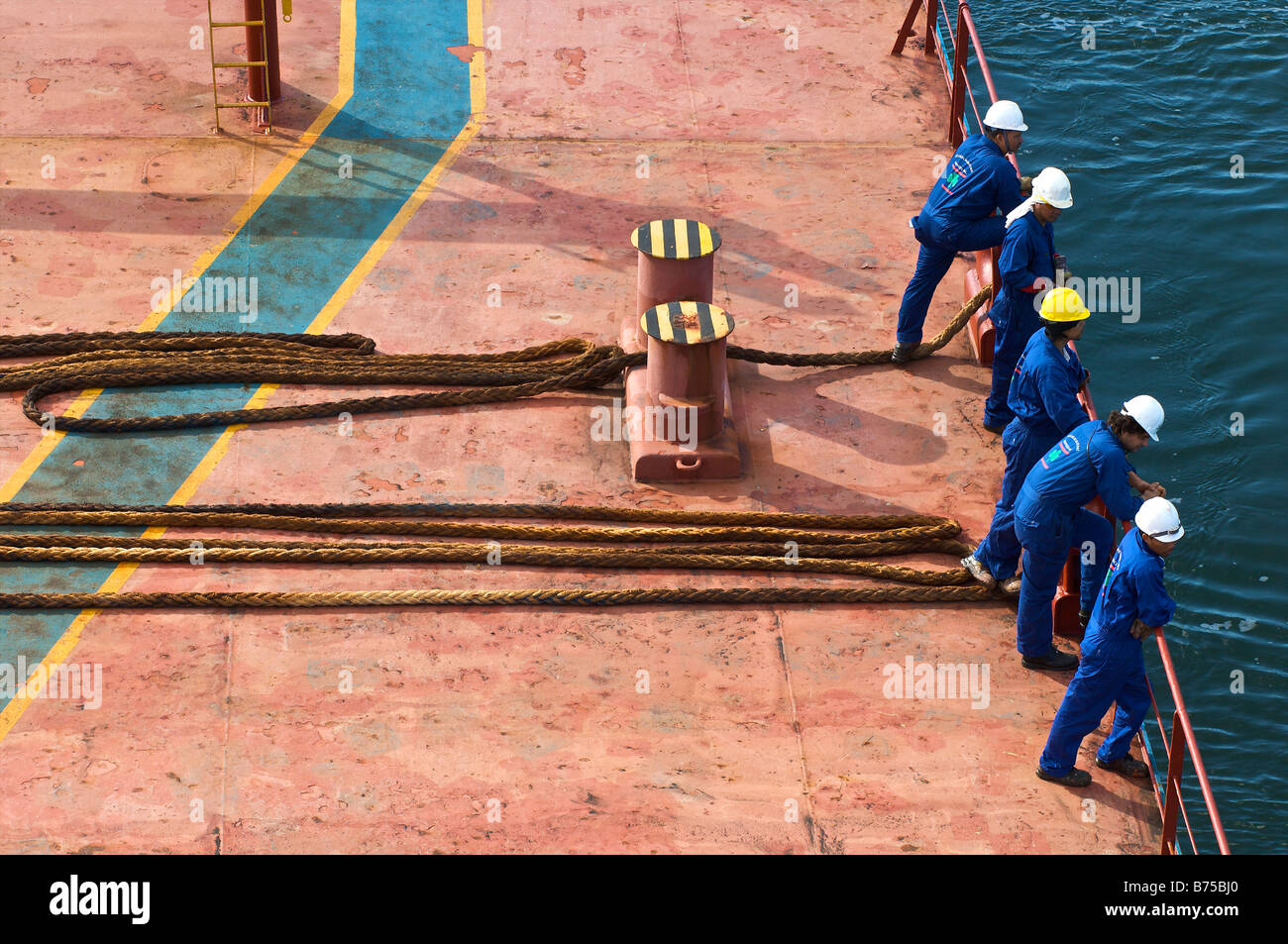 I membri dell'equipaggio in attesa sul ponte di una nave portarinfuse a gettare le linee Foto Stock