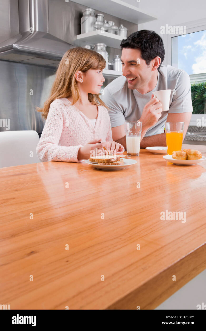 Metà uomo adulto avente la colazione con sua figlia Foto Stock