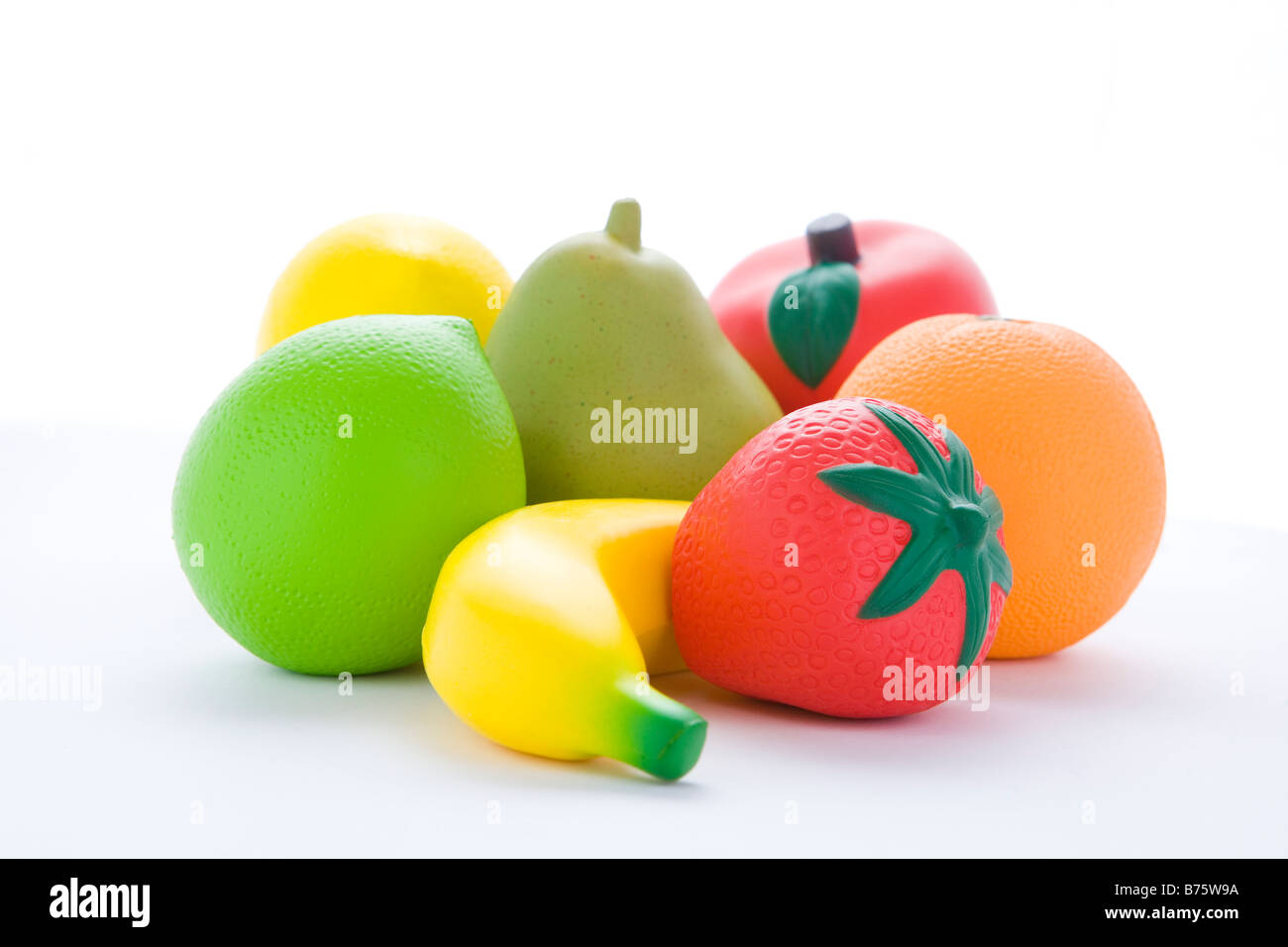 Selezione di Frutta artificiale su sfondo bianco Foto Stock