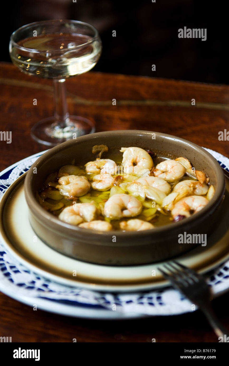 Gambas al ajillo, gamberi in padella con aglio e olio e un bicchiere di Cava spagnolo vino spumante in Tapas Bar Foto Stock