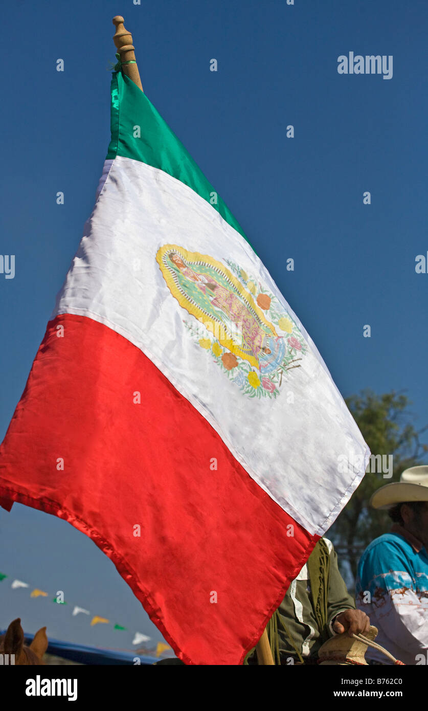 Cowboy messicano giro con una bandiera messicana al festival della Vergine di Guadalupe LOS RODRIGUEZ GUANAJUATO MESSICO Foto Stock