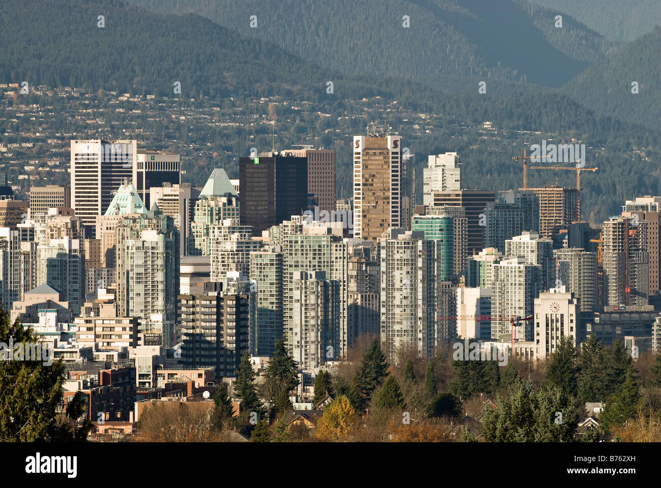 Vista la sempre mutevole skyline di l'area del centro cittadino di Vancouver insieme contro le montagne sulla North Shore. Foto Stock