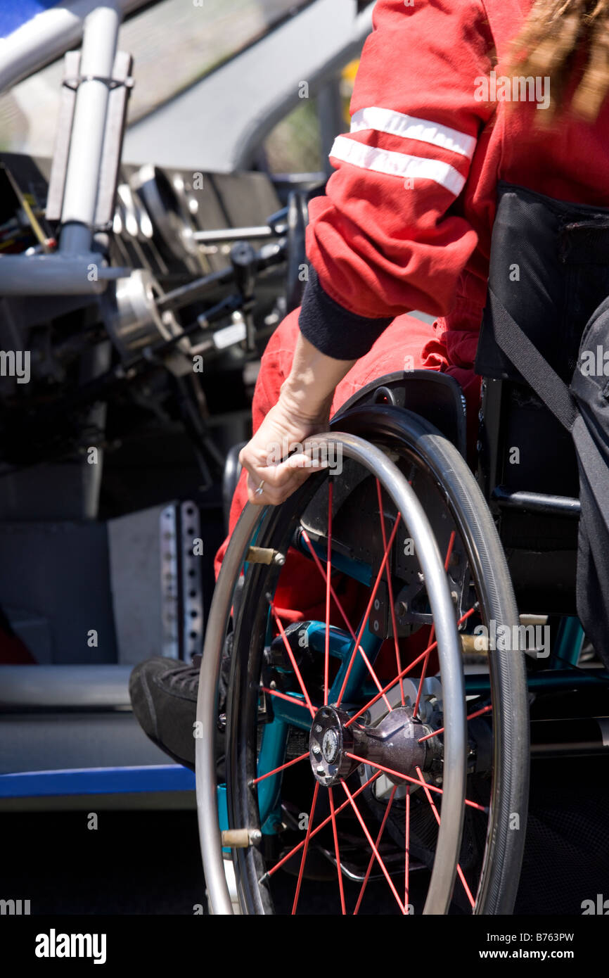 Donna di entrare sedile conducente delle corse di auto dalla sedia a rotelle, close-up Foto Stock
