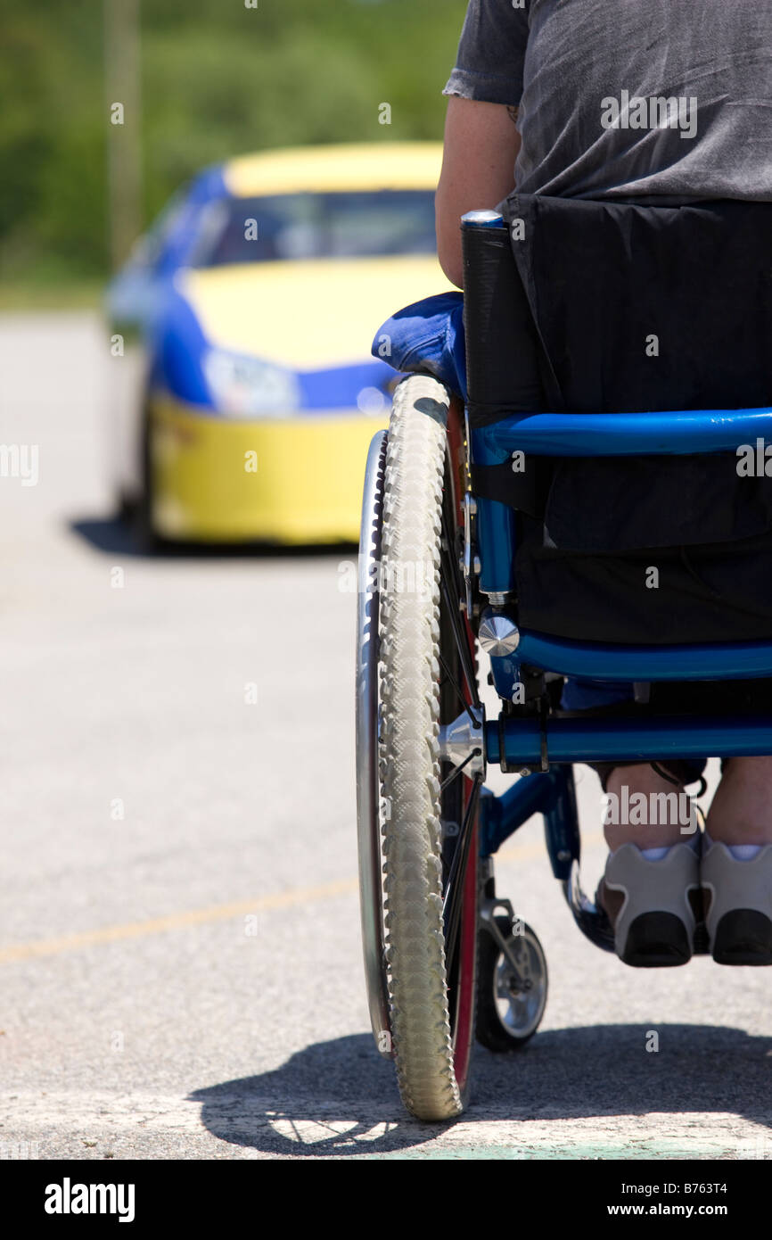 Persona sulla sedia a rotelle rivolto verso racing car, vista posteriore Foto Stock