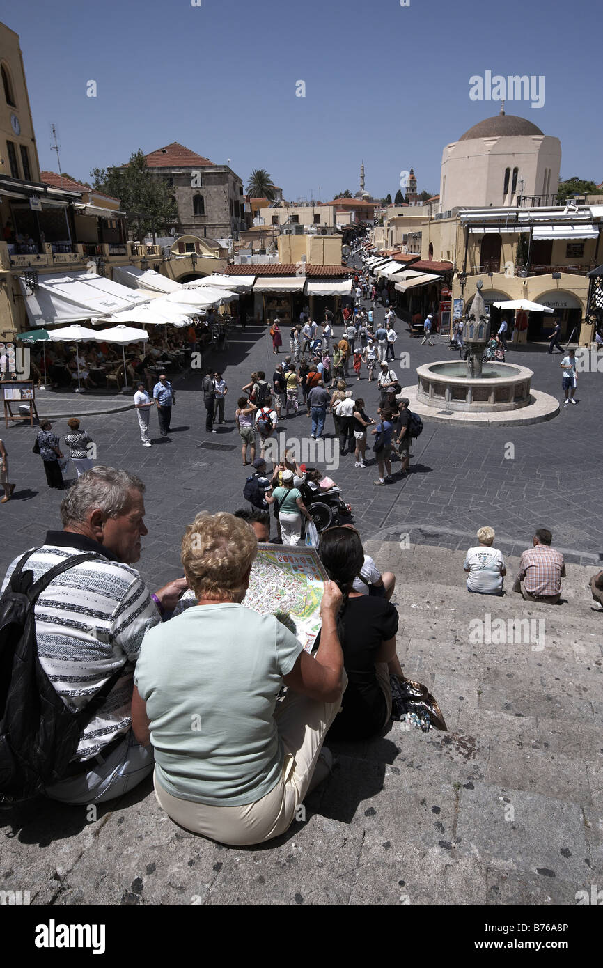 I turisti alla ricerca di una mappa in Platia Ippokratous piazza principale Rodi Isola di Rodi Grecia Foto Stock