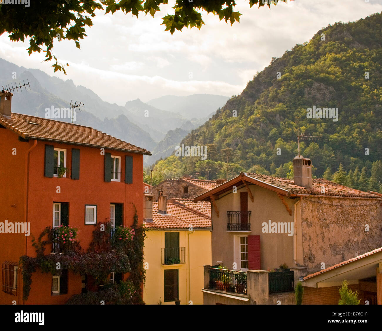 Una vista delle montagne dei Pirenei sulle tipiche case francesi dalla piazza di Vernet Les Bains, Languedoc Foto Stock