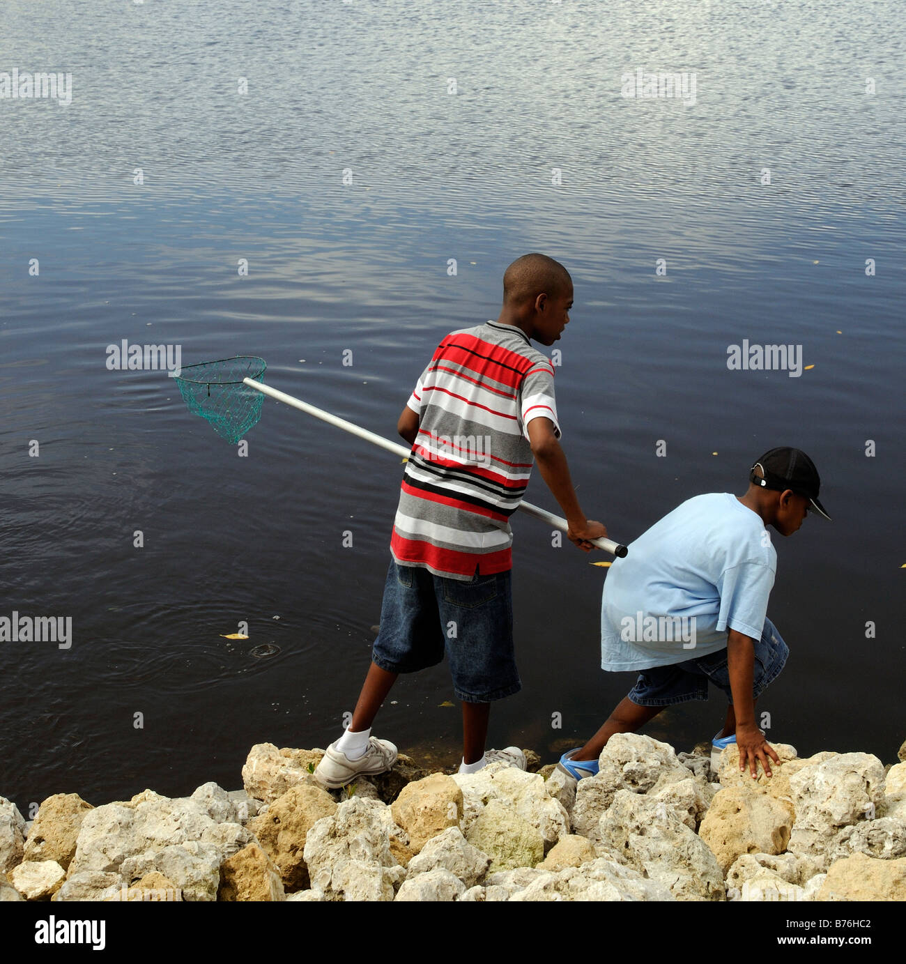 J N Ding Darling National Wildlife Refuge Sanibel Island Florida USA giovane nero ragazzi la pesca dei granchi Foto Stock