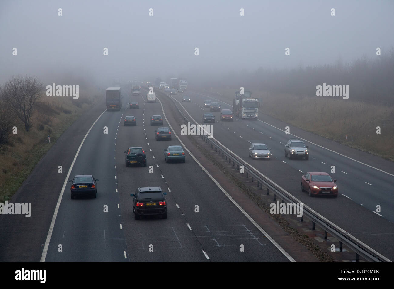Automobili e camion sull'autostrada nella nebbia , Regno Unito Foto Stock