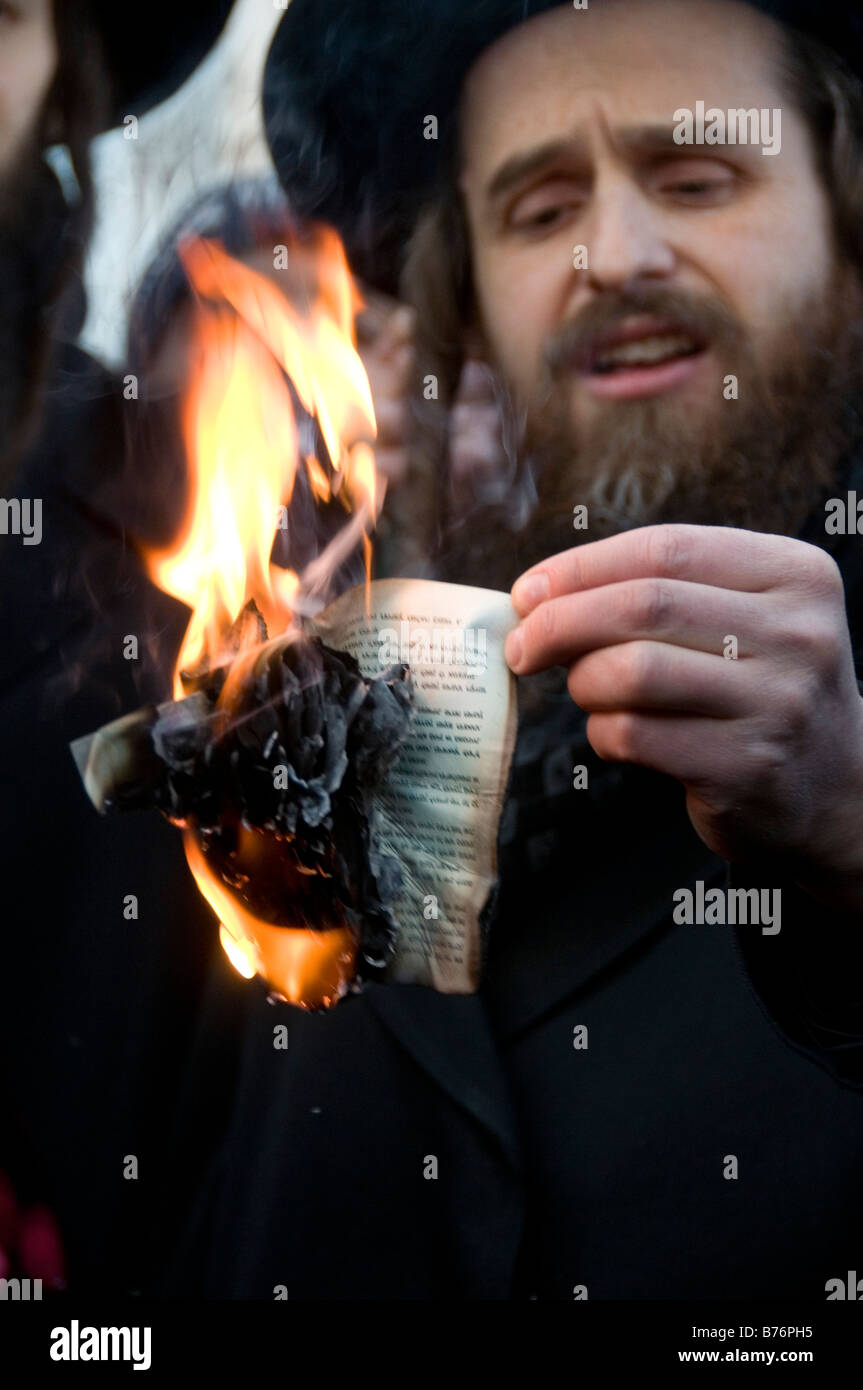 Rabbi Beck tenere la masterizzazione di passaporto israeliano di Rabbi Greenberg a una protesta contro il bombardamento di Gaza Foto Stock