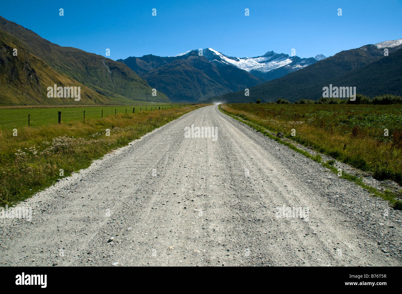 Una strada di campagna nella valle di Matukituki con il Monte Avalanche in lontananza, Monte aspirante Parco Nazionale, Isola del Sud, Nuova Zelanda Foto Stock